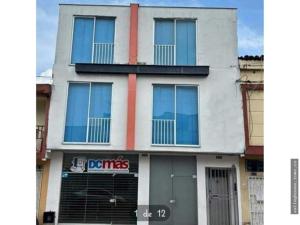 a white building with a red stripe on it at Apto Amoblado Alameda Cali in Cali