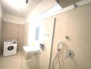 een badkamer met een wasmachine en een wastafel bij Sievering18 A-B in Wenen