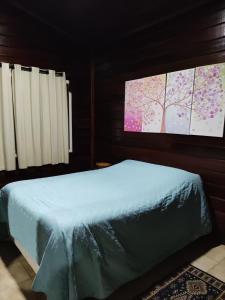 a bedroom with a bed with two monitors on the wall at Chalé Manacá House in Campos do Jordão