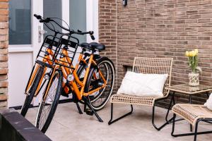 an orange bike parked next to a brick wall at Casa la Vida Beach House in Zandvoort