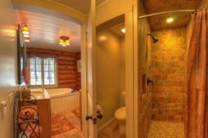 y baño con bañera, aseo y ducha. en Historic Log Cabin #14 at Horse Creek Resort en Rapid City