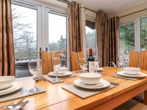 uma mesa de jantar com copos e pratos em Wainwright Lodge em Windermere