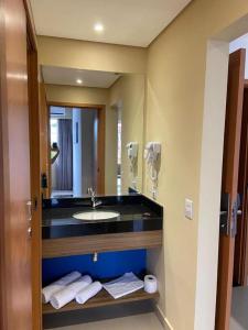 a bathroom with a sink and a mirror at 1 suite no Aguas de São Pedro Thermas Resort in São Pedro