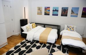 a bedroom with two beds and a couch at Luxury Apartments for up to 6 Guests in Central Location in London