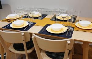 a table with chairs and plates and wine glasses at Luxury Apartments for up to 6 Guests in Central Location in London