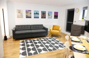a living room with a black couch and a table at Luxury Apartments for up to 6 Guests in Central Location in London