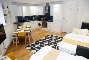 a kitchen with two beds and a table in a room at Luxury Apartments for up to 6 Guests in Central Location in London