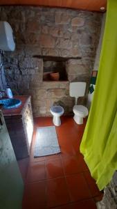 ein Badezimmer mit 2 WCs und einer Steinmauer in der Unterkunft Atelier.Germana in CastellʼUmberto Vecchio