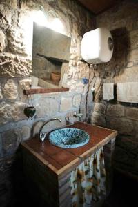 ein Steinbad mit einem Waschbecken und einem Spiegel in der Unterkunft Atelier.Germana in CastellʼUmberto Vecchio