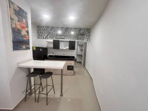 a small kitchen with a white table and stools at Apto Amoblado Alameda Cali in Cali