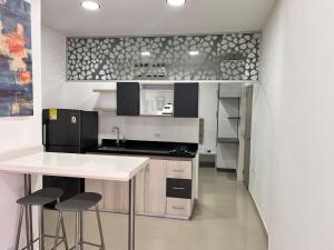 a kitchen with a white counter and stools in it at Apto Amoblado Alameda Cali in Cali