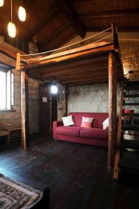 ein rotes Sofa in einem Zimmer mit Etagenbett in der Unterkunft Atelier.Germana in CastellʼUmberto Vecchio
