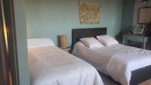 a bedroom with two beds and a table with a lamp at Les Oliviers : Studio spacieux belle vue mer, Clim in Port-Vendres