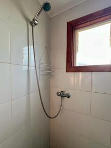 a shower in a bathroom with a window at Cabañas Ruta Lacustre in Licán Ray