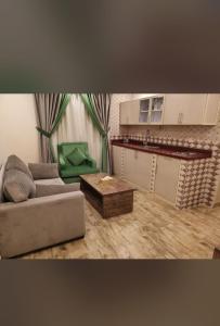 فندق العنقود - قريش في جدة: غرفة معيشة مع أريكة وطاولة