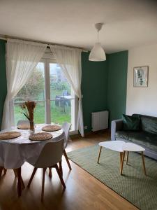 - un salon avec une table et un canapé dans l'établissement Appartement Port-En-Bessin Mer Proche, à Port-en-Bessin-Huppain