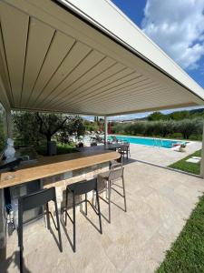 eine Terrasse mit einem Holztisch und Stühlen unter Markise in der Unterkunft Alle Vignole in Garda