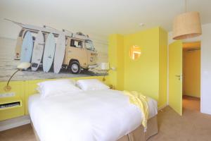 a bedroom with a bed and a van with surfboards on the wall at Hotel Casarose - Cannes Mandelieu in Mandelieu-la-Napoule