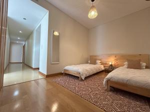 um quarto com 2 camas e um tapete em Oceanus Executive em Ponta Delgada