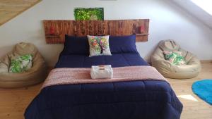 a bedroom with a large bed and two chairs at Chalet Laguna Sagrada de Fuquene in Fúquene