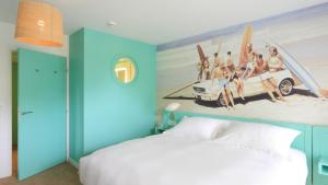 a bedroom with a bed with a painting on the wall at Hotel Casarose - Cannes Mandelieu in Mandelieu-la-Napoule