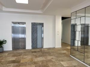 an empty room with two elevators and glass doors at Delta Center , loft 51 ms , frente a Nordelta. in Benavídez
