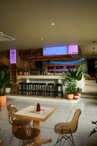 a restaurant with a table and chairs and a bar at The Somos Flats Central Poblado in Medellín