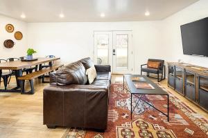 sala de estar con sofá de cuero y mesa en Near Downtown Stylish 2BR With Amazing Patio - 5, en Moab