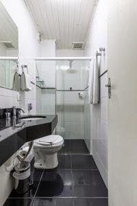 a bathroom with a toilet and a glass shower at Pousada Saint Gallen in Campos do Jordão