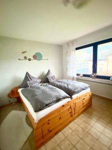 - une chambre avec un lit en bois dans une pièce dotée d'une fenêtre dans l'établissement Ferienwohnung Zum König, à Bremm