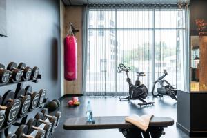a gym with bikes and exercise equipment in a room at Moxy Wuerzburg in Würzburg