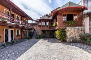 a house with a stone driveway in front of a building at Pousada Saint Gallen in Campos do Jordão