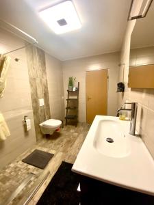 La salle de bains est pourvue d'un lavabo et de toilettes. dans l'établissement Ferienwohnung Zum König, à Bremm
