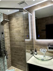 a bathroom with a glass shower with a sink at The Jewel in Kingston
