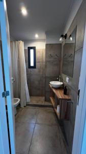 a bathroom with a sink and a toilet and a mirror at Las Marias Apart I in Necochea