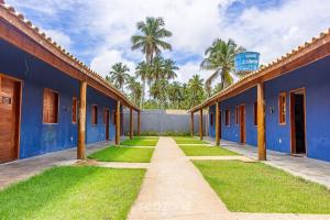 une rangée de bâtiments bleus avec des palmiers en arrière-plan dans l'établissement VDA - Casas encantadoras e próximas à praia Camaragibe/AL, à Passo de Camarajibe
