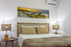 - une chambre avec un lit avec deux lampes et un tableau mural dans l'établissement VDA - Casas encantadoras e próximas à praia Camaragibe/AL, à Passo de Camarajibe