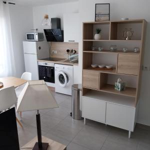 una piccola cucina con lavatrice e asciugatrice di Appartement cosy proche Disney a Ferrières-en-Brie