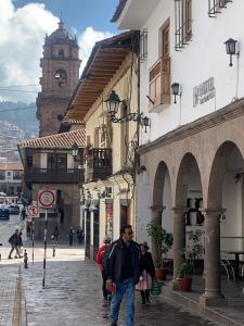 a man walking down a street in a city at Hotel San Pedro Plaza in Cusco