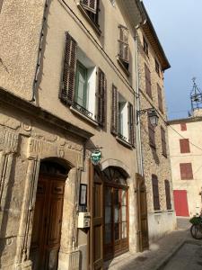 un edificio antiguo con puertas y ventanas en una calle en La Cachette du Comte, en Montfort-sur-Argens