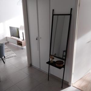 ein Spiegel, der neben einem Raum auf einem Stand sitzt in der Unterkunft Appartement cosy proche Disney in Ferrières-en-Brie