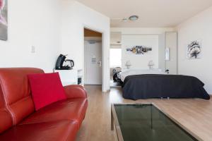 - un salon avec un lit et un canapé rouge dans l'établissement Seaside, à Zandvoort