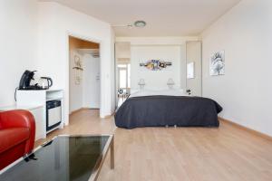 - une chambre avec un lit et un canapé rouge dans l'établissement Seaside, à Zandvoort