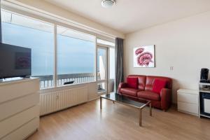 - un salon avec un canapé rouge et une fenêtre dans l'établissement Seaside, à Zandvoort
