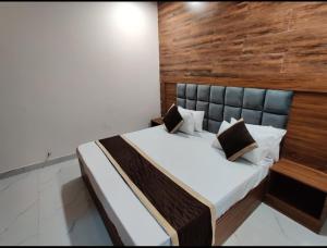 ein Schlafzimmer mit einem großen Bett und einer Holzwand in der Unterkunft The heaven(close to golden temple) in Amritsar