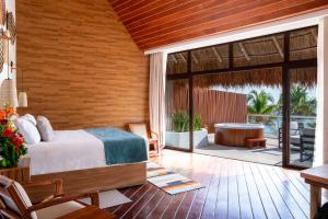 a bedroom with a bed and a patio with a tub at The Beachfront by The Fives Hotels in Playa del Carmen