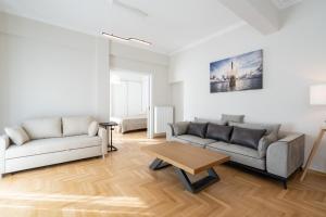 uma sala de estar com dois sofás e uma mesa em Corner Penthouse in Acropolis em Atenas