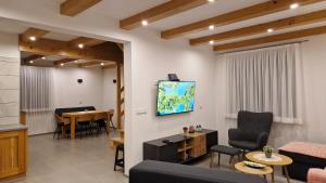 uma sala de estar com um sofá e uma televisão na parede em Plitvice Apis em Korenica