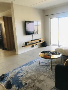 a living room with a table and a tv at Luxurious Lifestyle in Cape Town