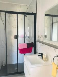 a white bathroom with a sink and a shower at Luxurious Lifestyle in Cape Town